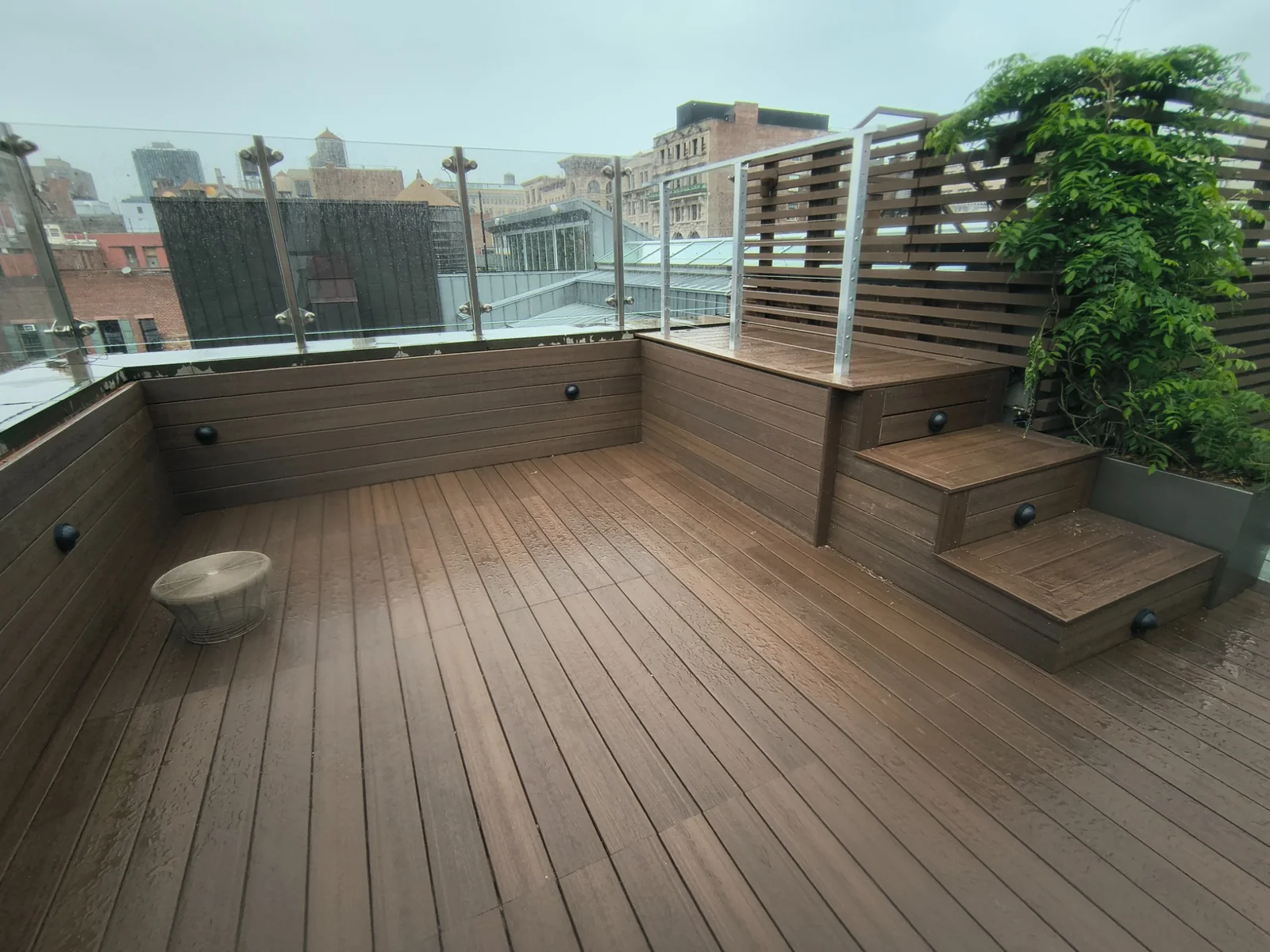 Finished Fiberon composite rooftop deck on a SoHo Manhattan penthouse with glass railing and skyline views