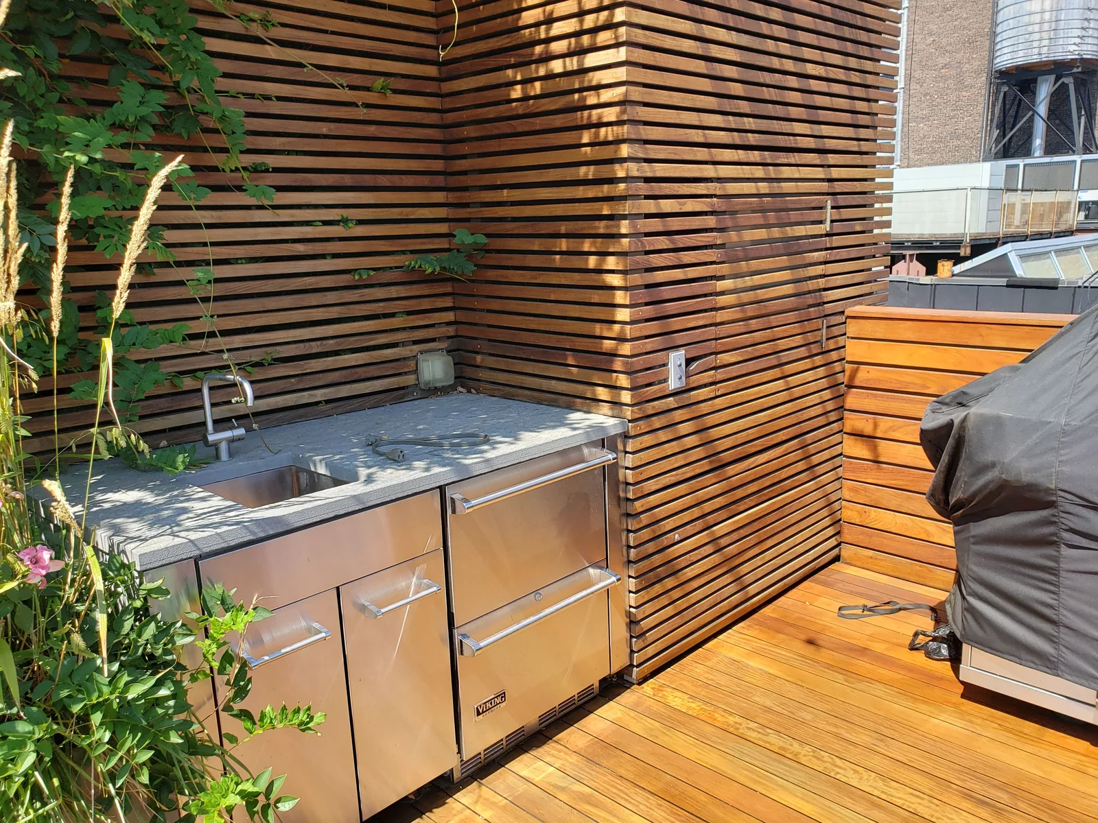 Outdoor kitchen slatted privacy screen by City Decks New York.