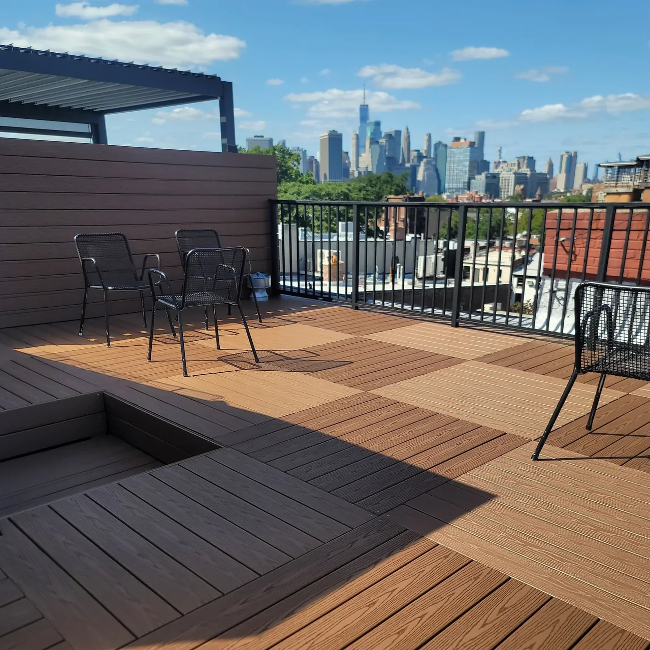 Private rooftop deck in Carroll Gardens Brooklyn with patterned decking, seating, and privacy screening